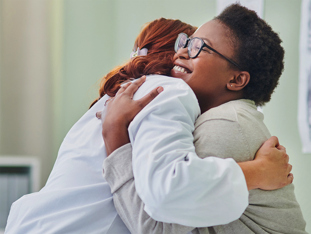 A doctor hugging a woman in a suit