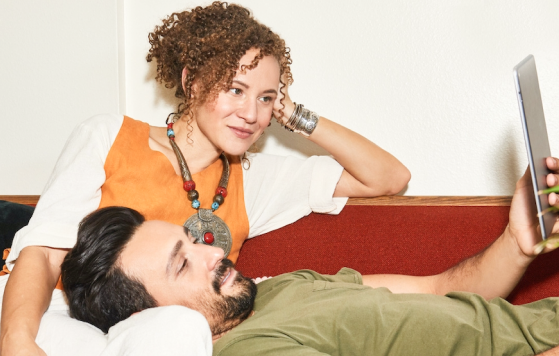 A couple on a sofa looking at a tablet