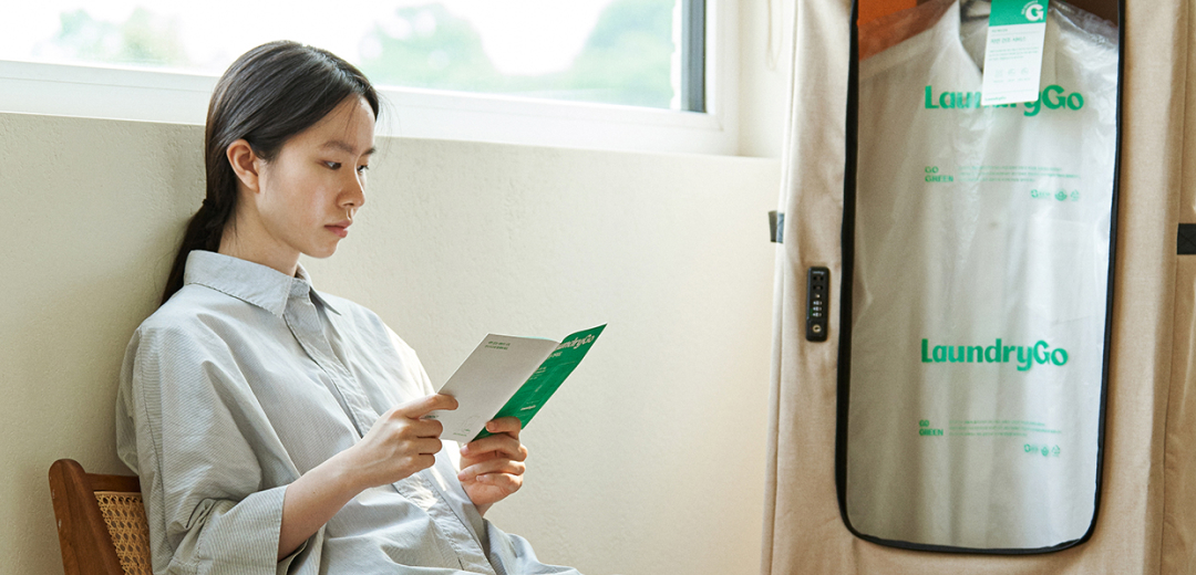 Women reading pamphlet in front of laundry bag